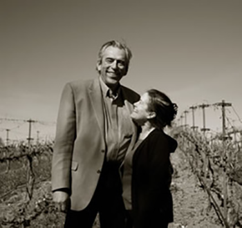 Tom Stolpman ’72 & Marilyn Stolpman ’72, J.D. ’76 standing in between grape vines