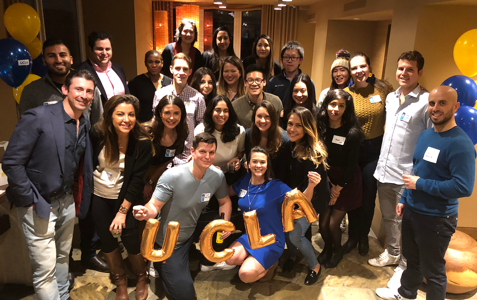 Frank and Nicci Roessler hold the UCLA balloon letters at their New York City Dinners for 12 Strangers.